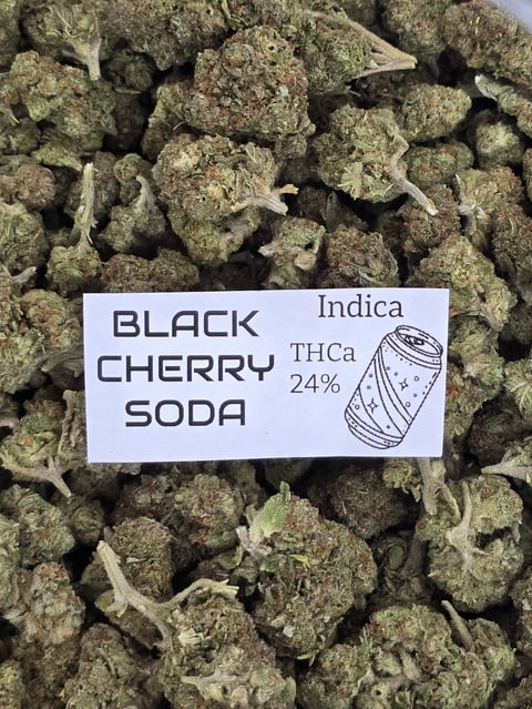Close-up of Black Cherry Soda cannabis buds with strain label showing Indica type and 24% THCa content