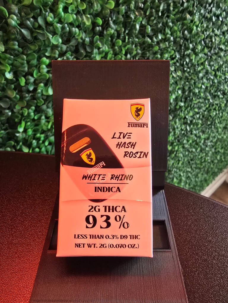 Orange cannabis product packaging for Fumari White Rhino Indica with 93% THCA live hash rosin on dark surface with green plant background