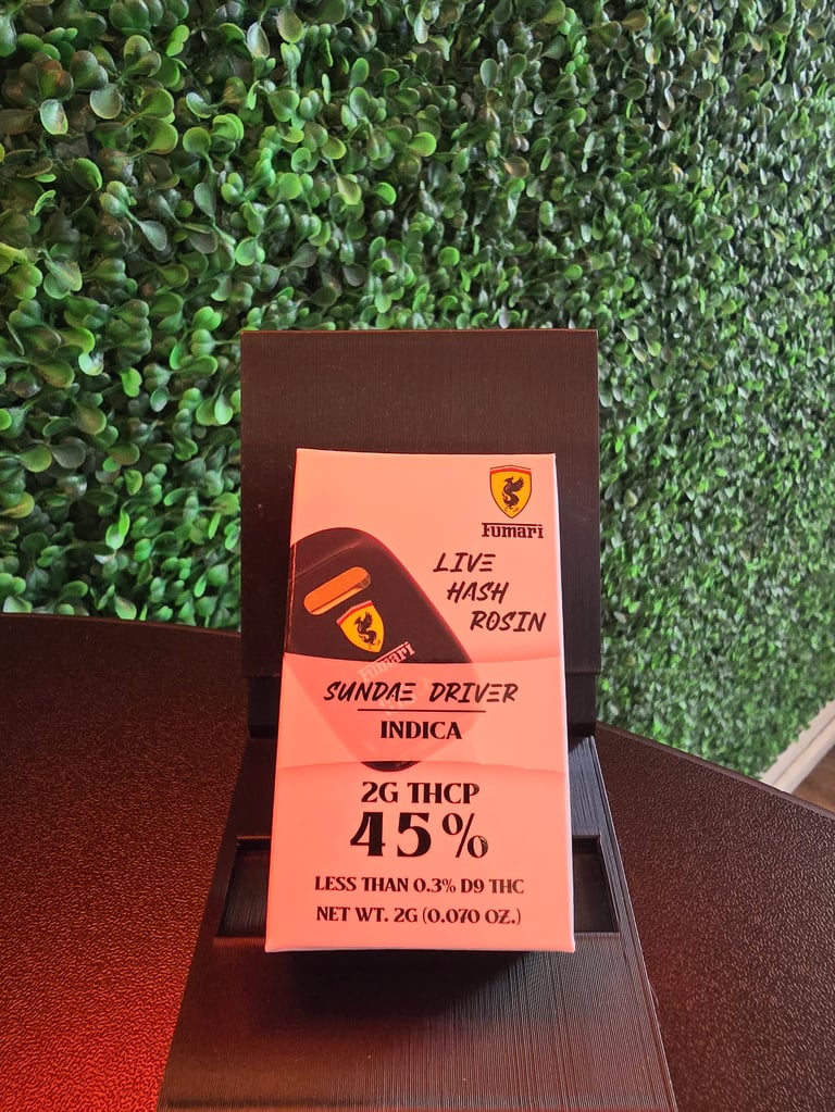 Cannabis product packaging for Sundae Driver Indica strain showing Ferrari branding, 2g THCP 45%, displayed on brown surface with green plant wall background