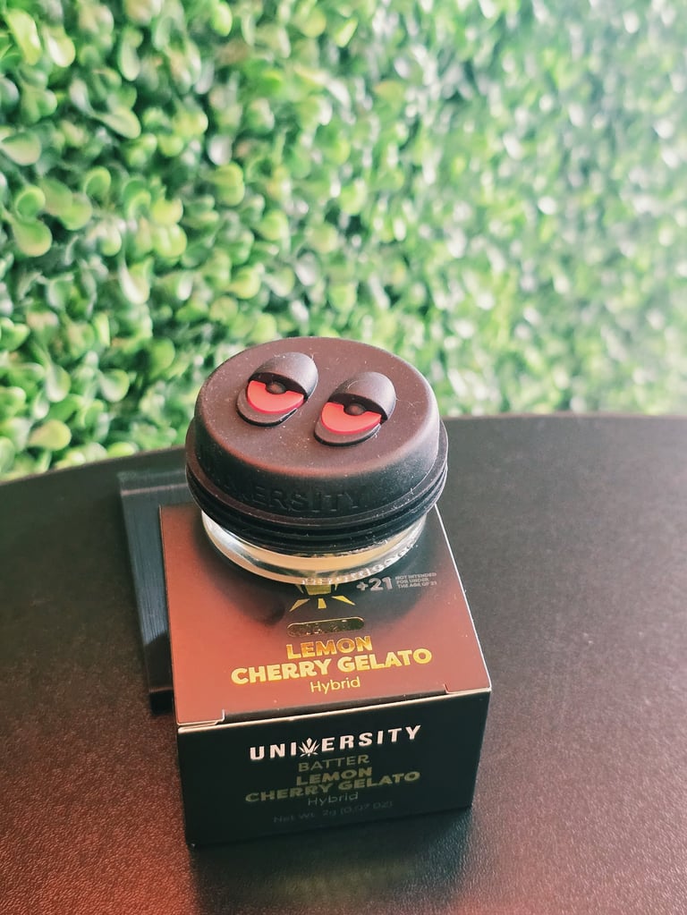 Lemon Cherry Gelato cannabis product with playful character face on jar sitting on branded black and orange box